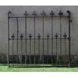 A VICTORIAN CAST IRON GARDEN GATE of two tier barred form with fleur de lys finials and scroll