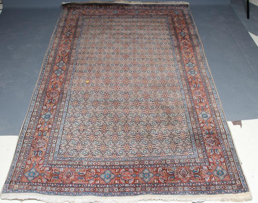 A PERSIAN RUG, the ivory field with all over repeating flowerhead and leaf pattern in shades of