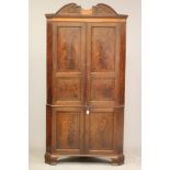 A GEORGIAN MAHOGANY STANDING CORNER CUPBOARD, c.1800, the moulded cornice with scrolled surmount