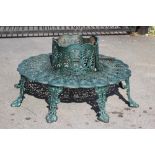 A CAST IRON TREE SEAT, modern, comprising two sections pierced with foliage, the raised back with