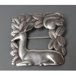 A GEORG JENSEN SILVER SQUARE BROOCH designed by Arno Malinowski, cast as a recumbent deer and