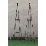 A PAIR OF WROUGHT IRON PLANT OBELISKS of tapering circular form with ball finial, rust patination,