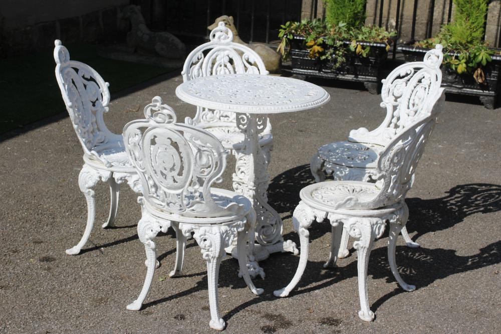 A COALBROOKDALE STYLE HEAVY CAST IRON TERRACE SUITE, comprising a circular table pierced with