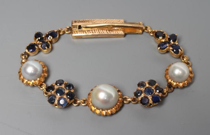 A SAPPHIRE AND PEARL BRACELET, the three graduated grey pearls set in frilled mounts between a