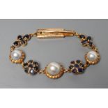 A SAPPHIRE AND PEARL BRACELET, the three graduated grey pearls set in frilled mounts between a