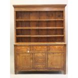 A GEORGIAN OAK ENCLOSED DRESSER c.1800, the delft rack with moulded cornice over reeded frieze and