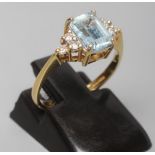 AN AQUAMARINE AND DIAMOND RING, the oblong facet cut aquamarine claw set between shoulders each