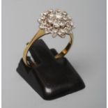 A DIAMOND CLUSTER RING, the central seven stone cluster to a border of twelve smaller stones and