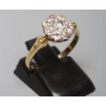 A NINE STONE DIAMOND CLUSTER RING, the old brilliant cut stones set to a plain shank stamped 18ct,