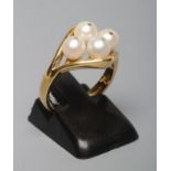 A PEARL DRESS RING, the four cultured pearls "show peg" set to an open lozenge panel and plain