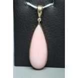 A PINK CHALCEDONY PENDANT, the shaped polished stone collet set in 9ct gold with a diamond point