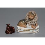 A STAFFORDSHIRE PORCELANEOUS LION, c.1830, modelled recumbent with shredded clay mane, a tiny lamb