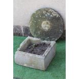 A SANDSTONE MILL WHEEL, 23 1/2" high, together with a square sandstone trough, 18" x 18" x 9" (2) (