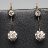 A PAIR OF DIAMOND EAR DROPS, the open back collet set stone of approximately 0.12cts pendant with