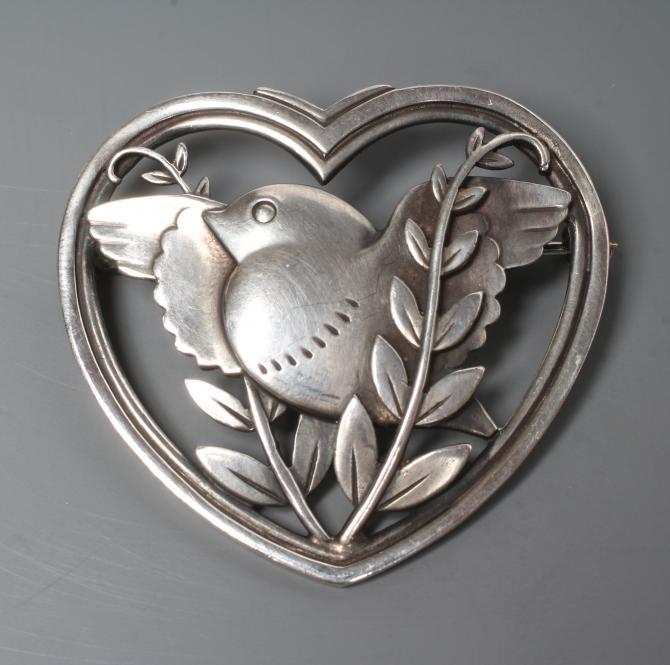 A GEORG JENSEN SILVER HEART SHAPED BROOCH designed by Arno Malinowski with a dove and olive