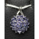 A TANZANITE CLUSTER PENDANT, the circular and marquise cut stones point set to a plain 9ct white