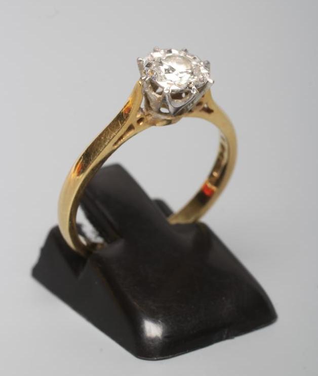 A SOLITAIRE DIAMOND RING, the round brilliant cut stone of 0.31cts illusion set to a plain 18ct gold
