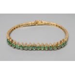 AN EMERALD AND DIAMOND BRACELET, the sixteen circular facet cut emeralds each flanked by two small