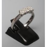 A THREE STONE DIAMOND RING, the Princess cut stones point set to a plain platinum shank, size N (
