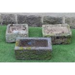 A SMALL SANDSTONE TROUGH of rough hewn oblong form, 18" x 12"x 8", another, 20" x 11"x 7 3/4", and a