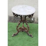A VICTORIAN CAST IRON TABLE with associated sandstone circular top, the triform scrolling foliate