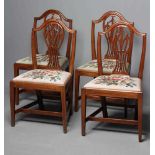 A SET OF FOUR GEORGIAN MAHOGANY DINING CHAIRS, late 18th century, the arched top rail over pierced