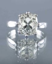 A SOLITAIRE DIAMOND RING, the cushion cut stone of 5.19cts, claw set to a plain platinum shank, size