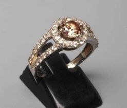 A CHAMPAGNE DIAMOND CLUSTER DRESS RING, the central round brilliant cut stone of approximately 0.