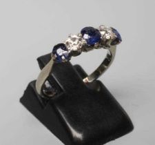 A FIVE STONE SAPPHIRE AND DIAMOND HALF HOOP RING, the three sapphires and two round brilliants