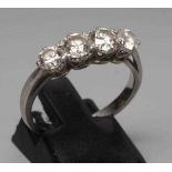 A FOUR STONE DIAMOND RING, the old brilliant cut stones each of approximately 0.23cts, claw set to a
