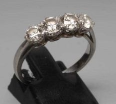 A FOUR STONE DIAMOND RING, the old brilliant cut stones each of approximately 0.23cts, claw set to a