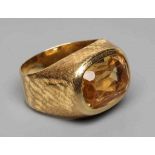 A GENTLEMAN'S DRESS RING, the oval facet cut citrine collet set to criss-cross engraved shoulders