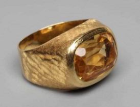 A GENTLEMAN'S DRESS RING, the oval facet cut citrine collet set to criss-cross engraved shoulders