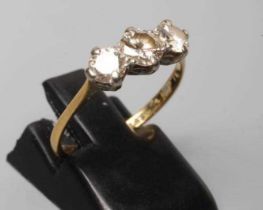 A THREE STONE DIAMOND RING, the old brilliant cut stones of approximately 0.4cts and 0.25cts, claw
