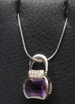 AN AMETHYST AND DIAMOND HANDBAG PENDANT, the facet cut shaped amethyst below eight small pave set