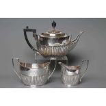 AN EDWARDIAN SILVER COMPOSITE THREE PIECE TEA SERVICE, teapot maker Huttons, London 1907, sugar
