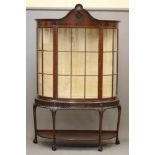 A MAHOGANY DISPLAY CABINET of bowed form, early 20th century, the multi panelled astragal glazed