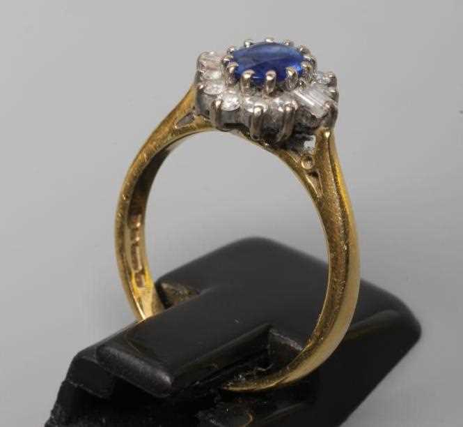 A SAPPHIRE AND DIAMOND CLUSTER RING, the oval facet cut sapphire claw set to a border of ten small - Image 2 of 2