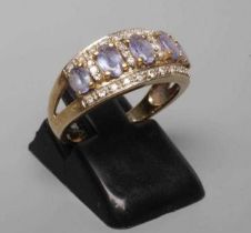 A TANZANITE AND DIAMOND HALF HOOP RING, the five graduated oblong facet cut tanzanites claw set to