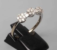 A DIAMOND TRIPLE CLUSTER RING, the seven stone small clusters with two pairs of baguette cut