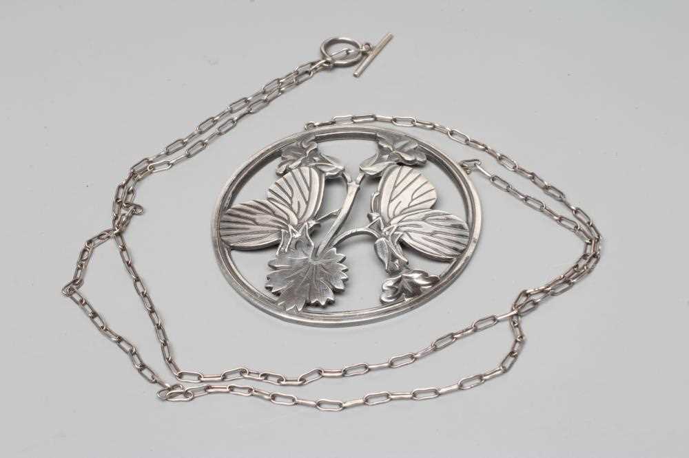 A GEORG JENSEN SILVER CIRCULAR PENDANT to match the previous lot, fixed to a fine chain necklace,