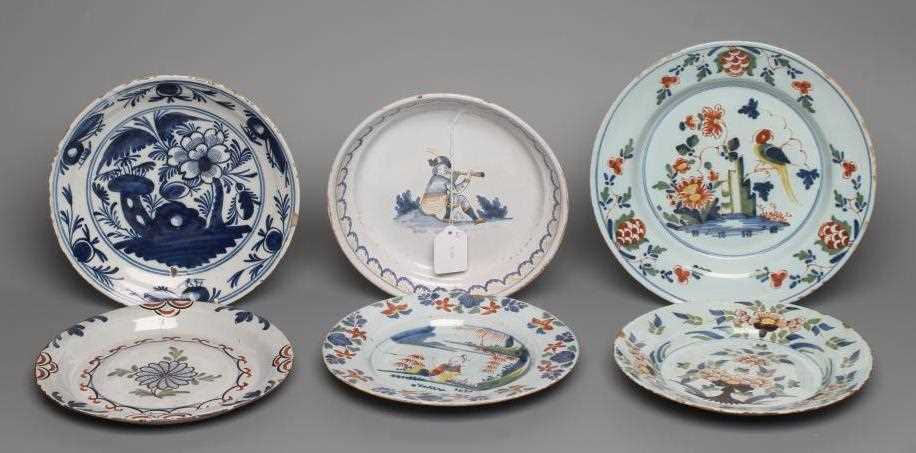 AN ENGLISH DELFT PLATE, London c.1740, painted in green, red, yellow and blue with a seated