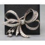 A DIAMOND BOW BROOCH, the white unmarked metal frame pave set with numerous round cut stones (Est.