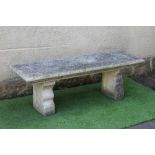 A CAST STONE BENCH, the moulded edged oblong seat raised on flower moulded square section end