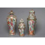 THREE CANTONESE PORCELAIN FAMILLE ROSE VASES AND COVERS of inverted baluster form, all painted