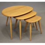 A NEST OF ERCOL MODEL 354 ELM "PEBBLE" TABLES, raised on turned beech supports, largest 25 3/4" x 17