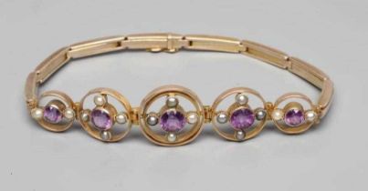 AN EDWARDIAN AMETHYST AND SEED PEARL BRACELET, the five graduated open circlets each centred by a