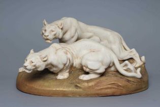 A ROYAL DUX BISQUE PORCELAIN MODEL OF TWO LIONESSES, early 20th century, both crouching and