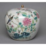A CHINESE PORCELAIN JAR AND COVER of rounded cylindrical form, painted in colours with an exotic