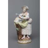 A MEISSEN PORCELAIN FIGURE, late 19th century, modelled as a shepherdess wearing a blue hat, lace